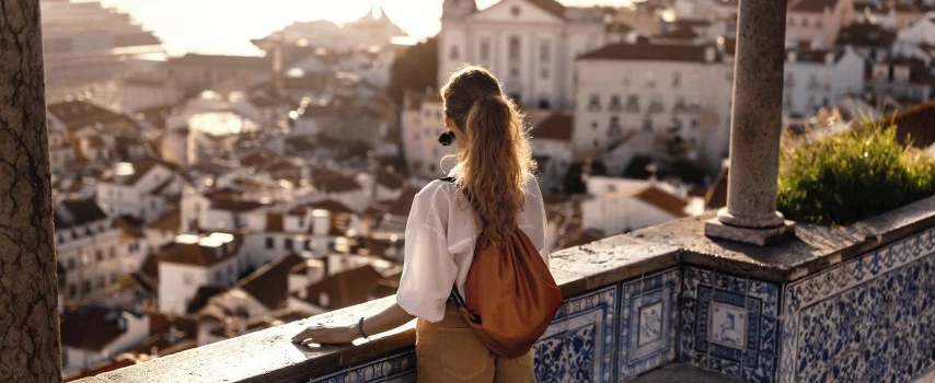 Female tourist looking at old town from balcony