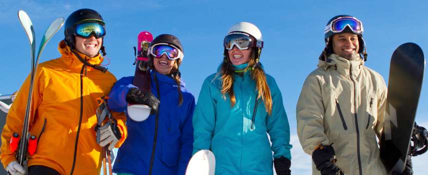 Group of friends who purchased travel insurance for skiing and snow sports excited to start their winter trip