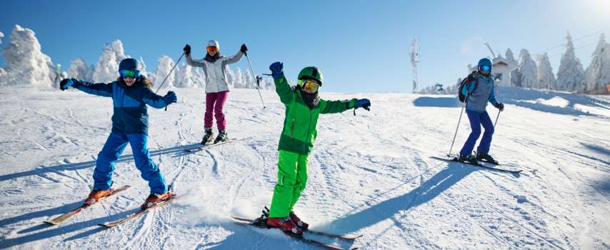 Family who purchased travel insurance for skiing enjoying their winter getaway on the slopes