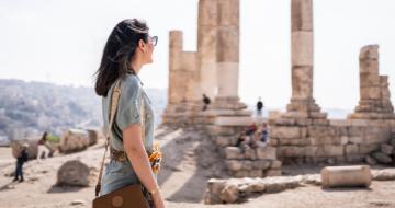 Girl with travel insurance explores ruins in Jordan
