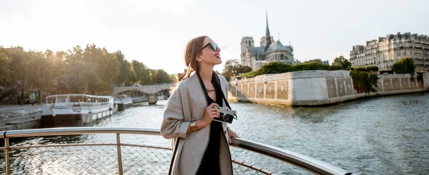 Woman enjoying landscape view on the riverside with Notre-Dame cathedral