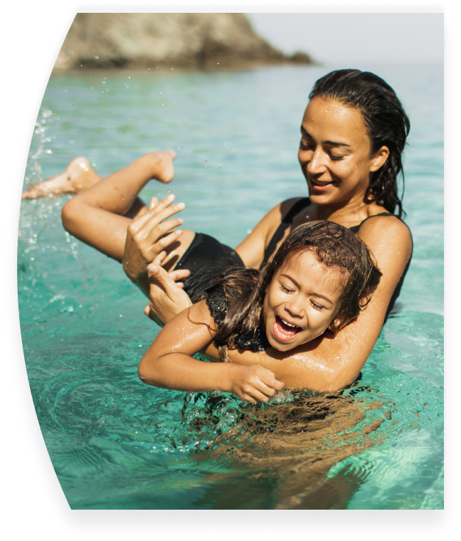 Mother and child swimming in calm ocean setting