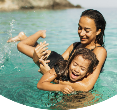 Mother and child swimming in calm ocean setting