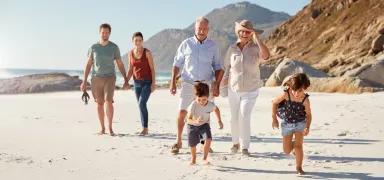 Multigenerational family walking on the beach