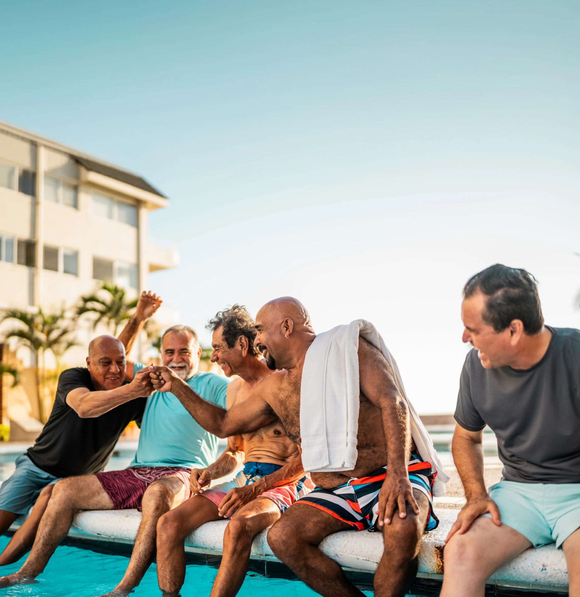 Group of men sitting near pool
