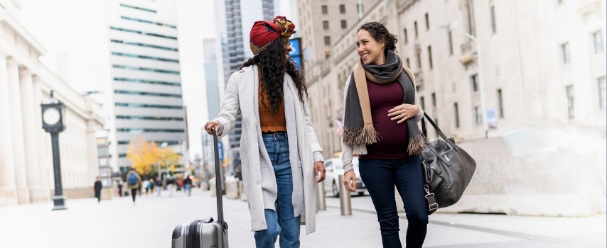 Pregnant traveller exploring city with friend