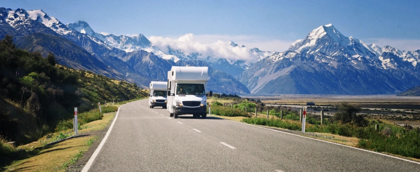 Campervan convoy through mountains in New Zealand