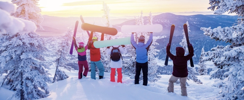 Group of snowboarders and skier having fun tossing snow