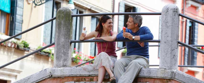 Couple eating gelato in Venice, because it's on their list of things to do in Europe