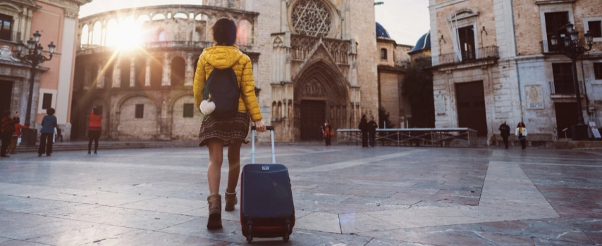 Lady walking pulling suitcase behind her