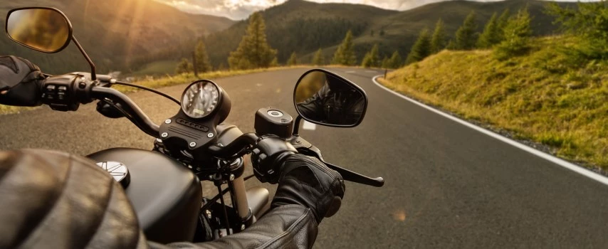 Motorbiker riding motorbike through Alps