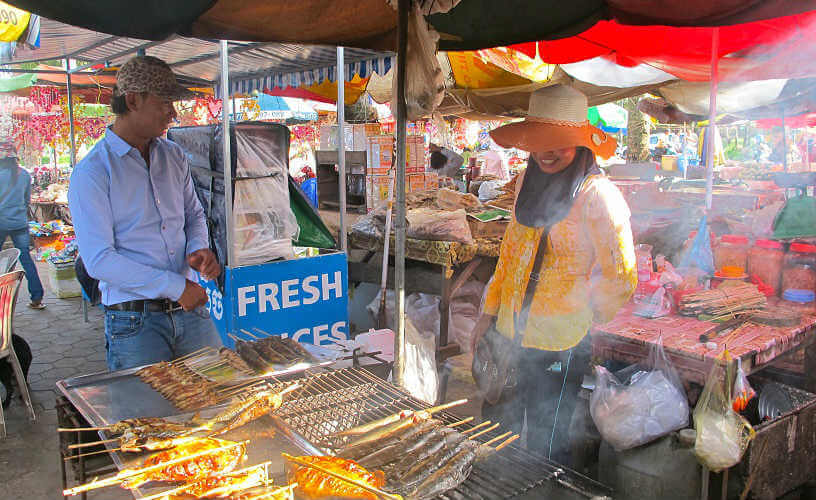 Locals grilling fish at the Crab Market, Cambodia