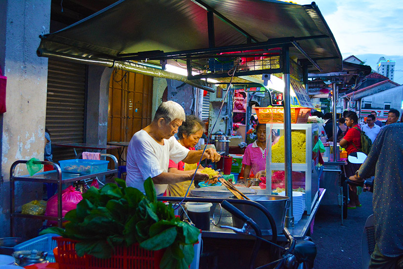 Local couple cooking and vending at street market. 