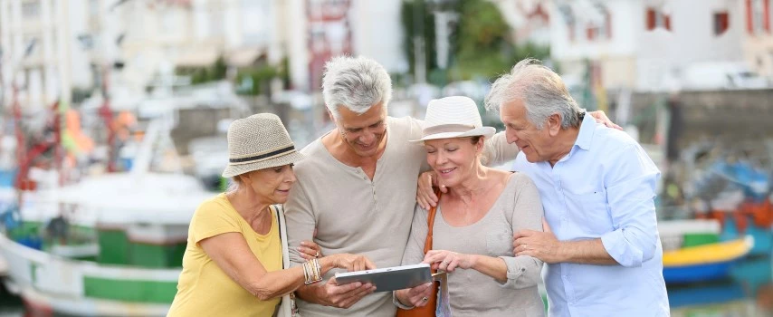 Senior couples looking at map together while travelling