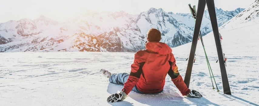 Skier sitting in alpes mountains on sunny day