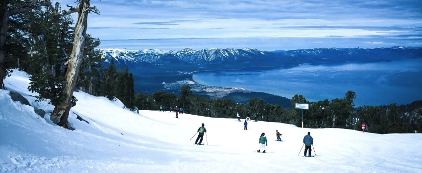 Skiers on mountain overlooking lake
