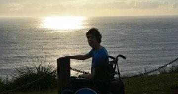 Thumbnail image of a young man in a wheelchair at the beach