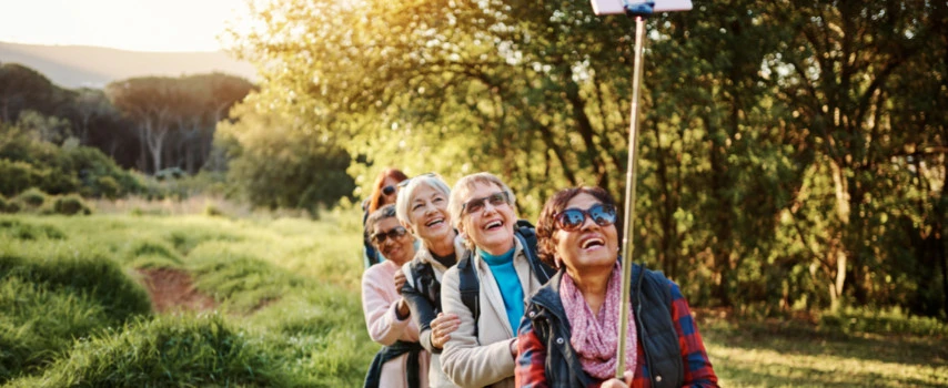 Group of older women with travel insurance take selfie during holiday