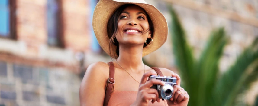 Female traveller with travel insurance takes photos during her trip
