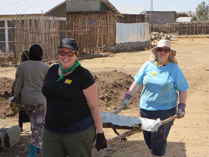 Photo of two women volunteering to build a chikka house in Ethiopia