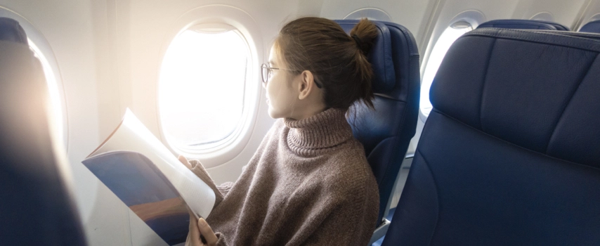 Woman reading magazine in airplane