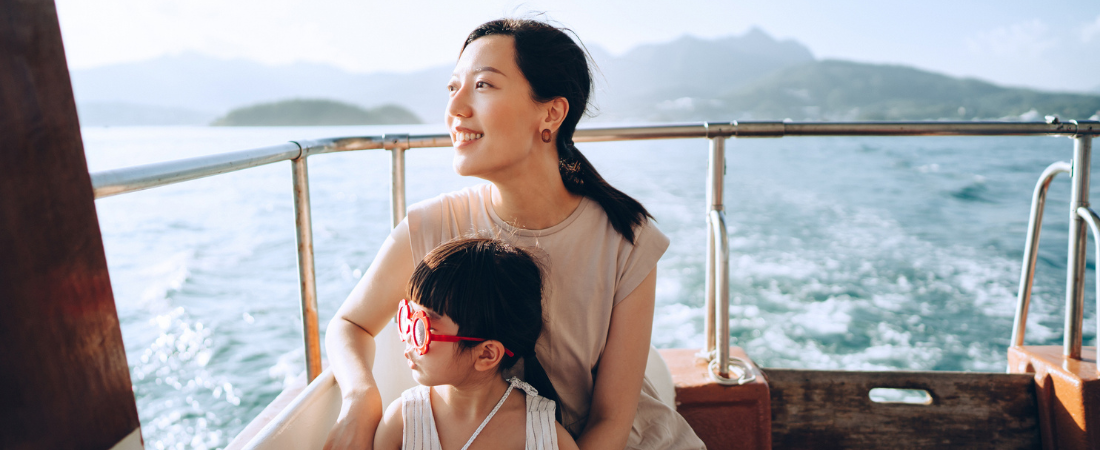 Mum and young daughter on a cruise ship, admiring the view 